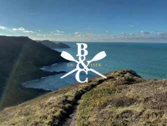 Seascape: Cambeak headland from Castle point with white Boscastle and Crackington Gig Club logo in the centre