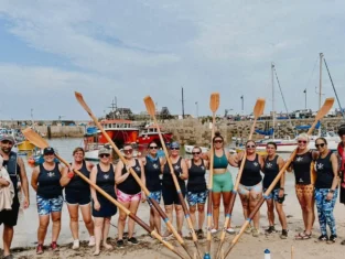Ladies Open Crews and coxes on the beach at Newquay Harbour